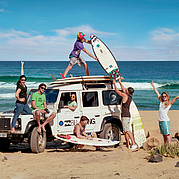 Surfeurs avec Land Rover Defender à la plage Surfeurs avec leurs planches à côté d'un Land Rover Defender sur un spot de surf de Fuerteventura.