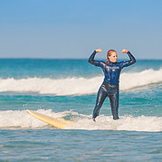 Célébration après le premier take-off Le premier take-off dans le cours de surf débutant est réussi – pure joie après avoir surfé ta première vague de mousse.