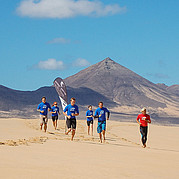 Échauffement par un léger jogging sur la plage Des élèves surfeurs s’échauffent en trottinant le long de la plage avant leur cours de surf à Fuerteventura.
