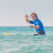 Hang Loose – le plaisir pur du surf Instant de bonheur après la vague – tu fais le signe Hang Loose avec un grand sourire.
