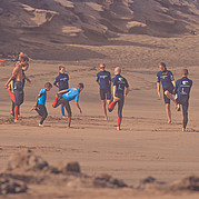 Échauffement en famille sur la plage Tu t’échauffes avec ta famille sur la plage – le plaisir du surf peut commencer.