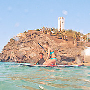 Le moniteur de SUP aide à se mettre debout sur la planche