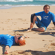 Heureux et fatigué après le cours Élève satisfait se repose sur la plage après une session intense de surf.